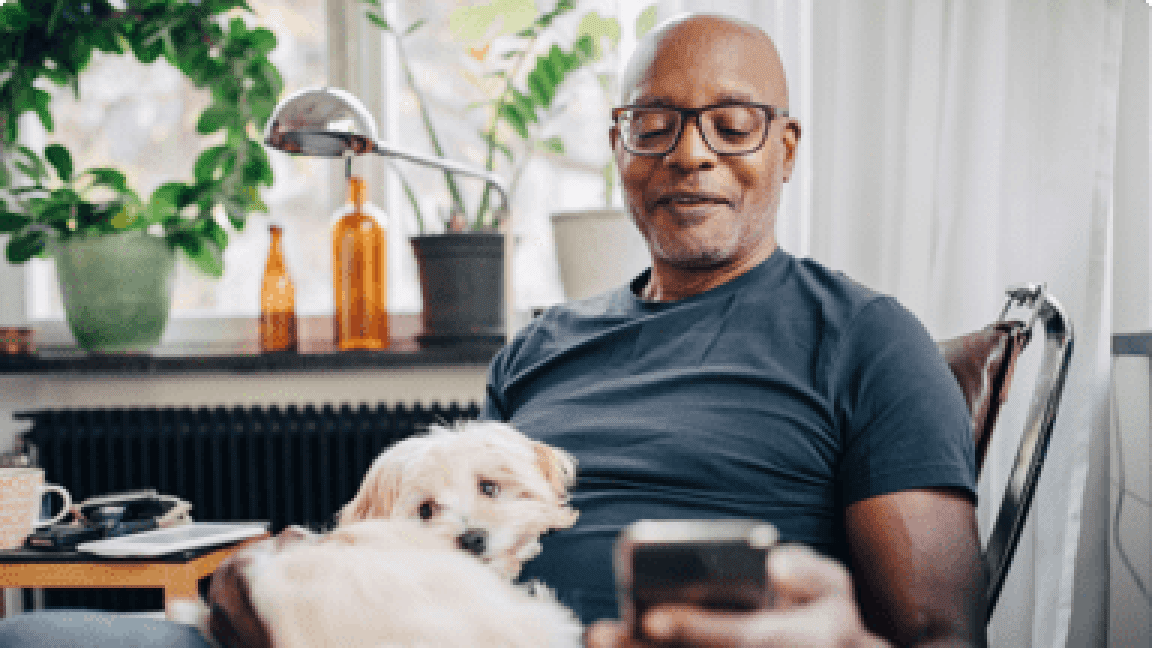 A man checking Stiolto iHub health tips on phone at home with his dog