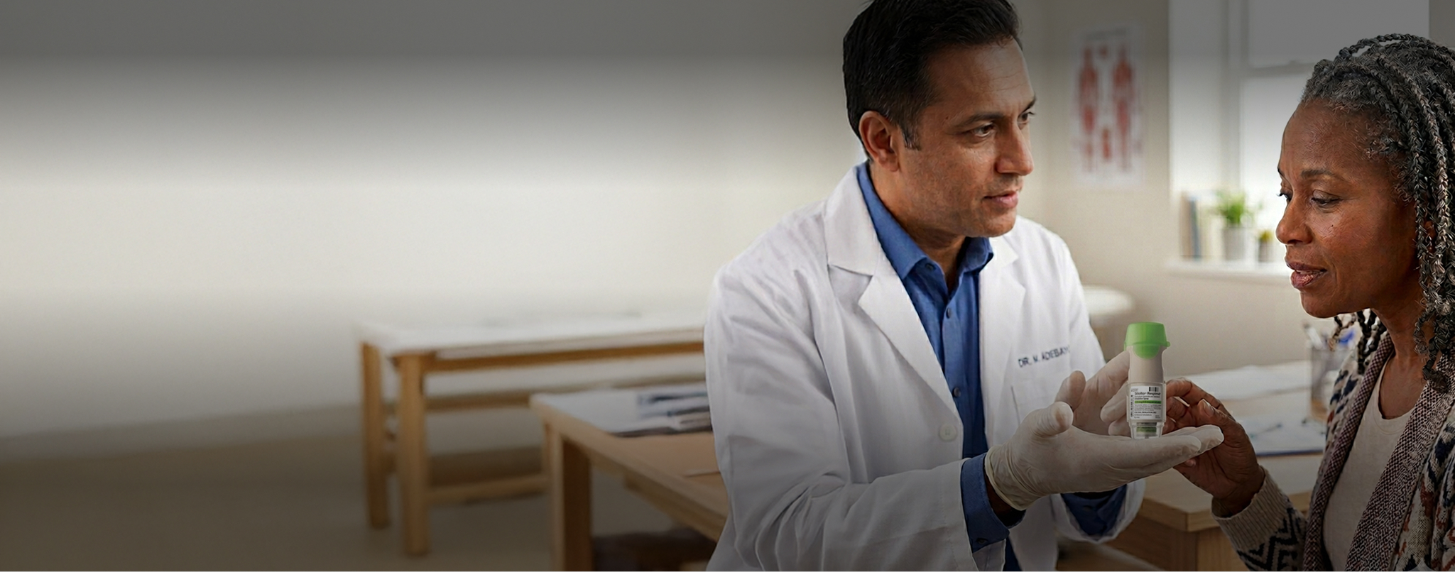 A healthcare professional showing a Stiolto Respimat inhaler to a senior patient